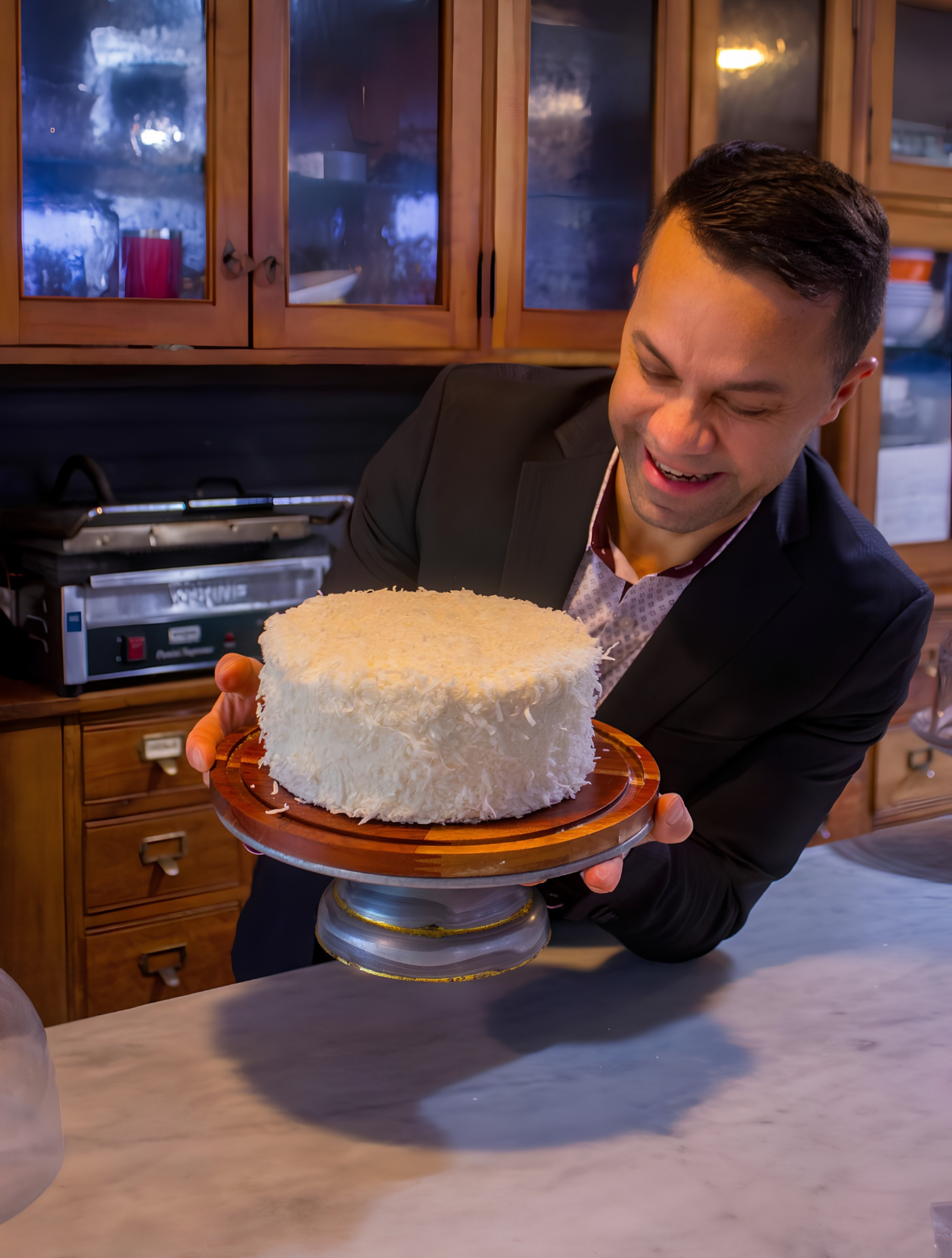 Fresh coconut cake from The Market at Union Hall bakery, held on a wooden cake stand