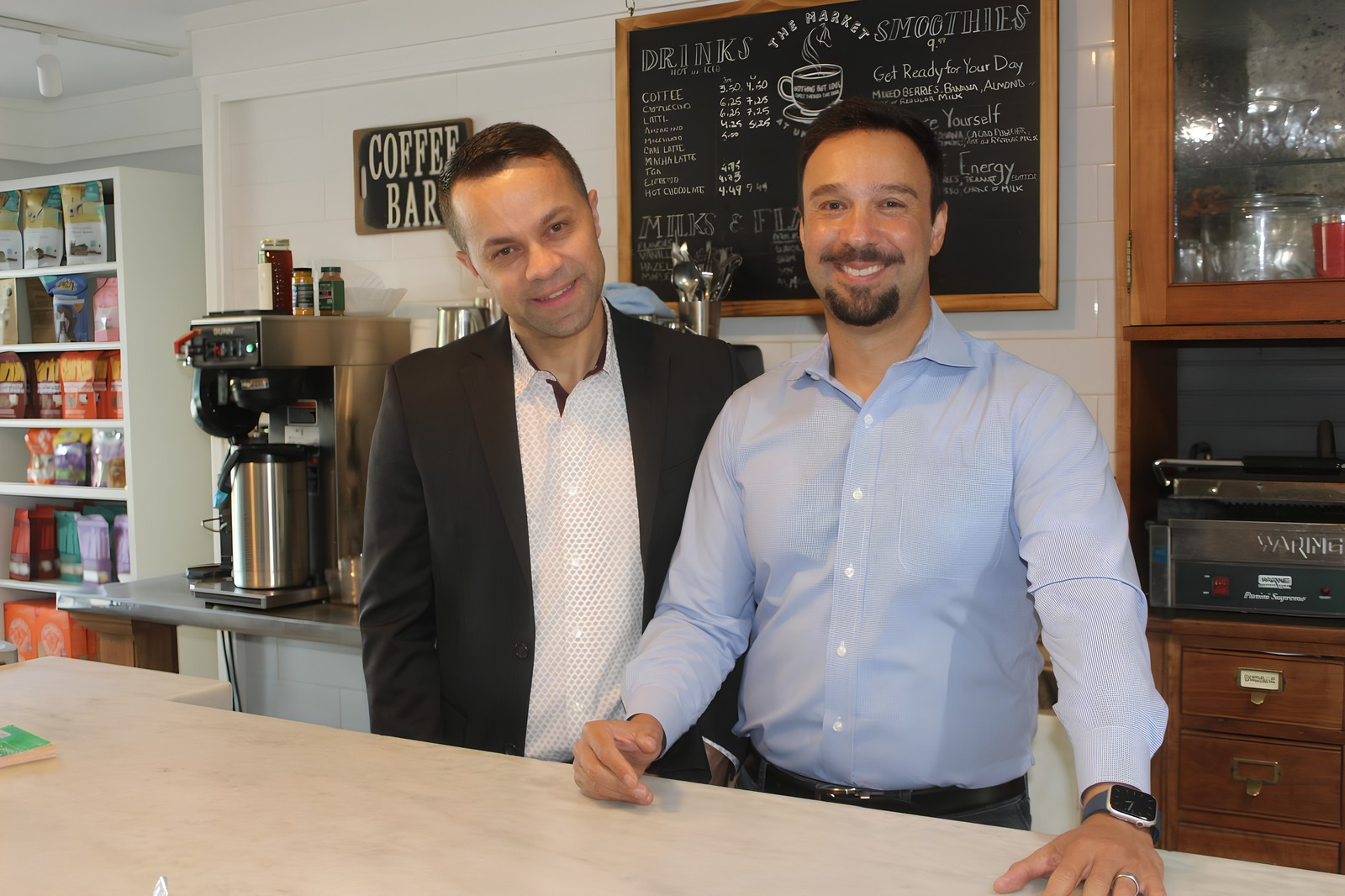 Daniel and his partner standing together behind the coffee bar counter inside The Market at Union Hall