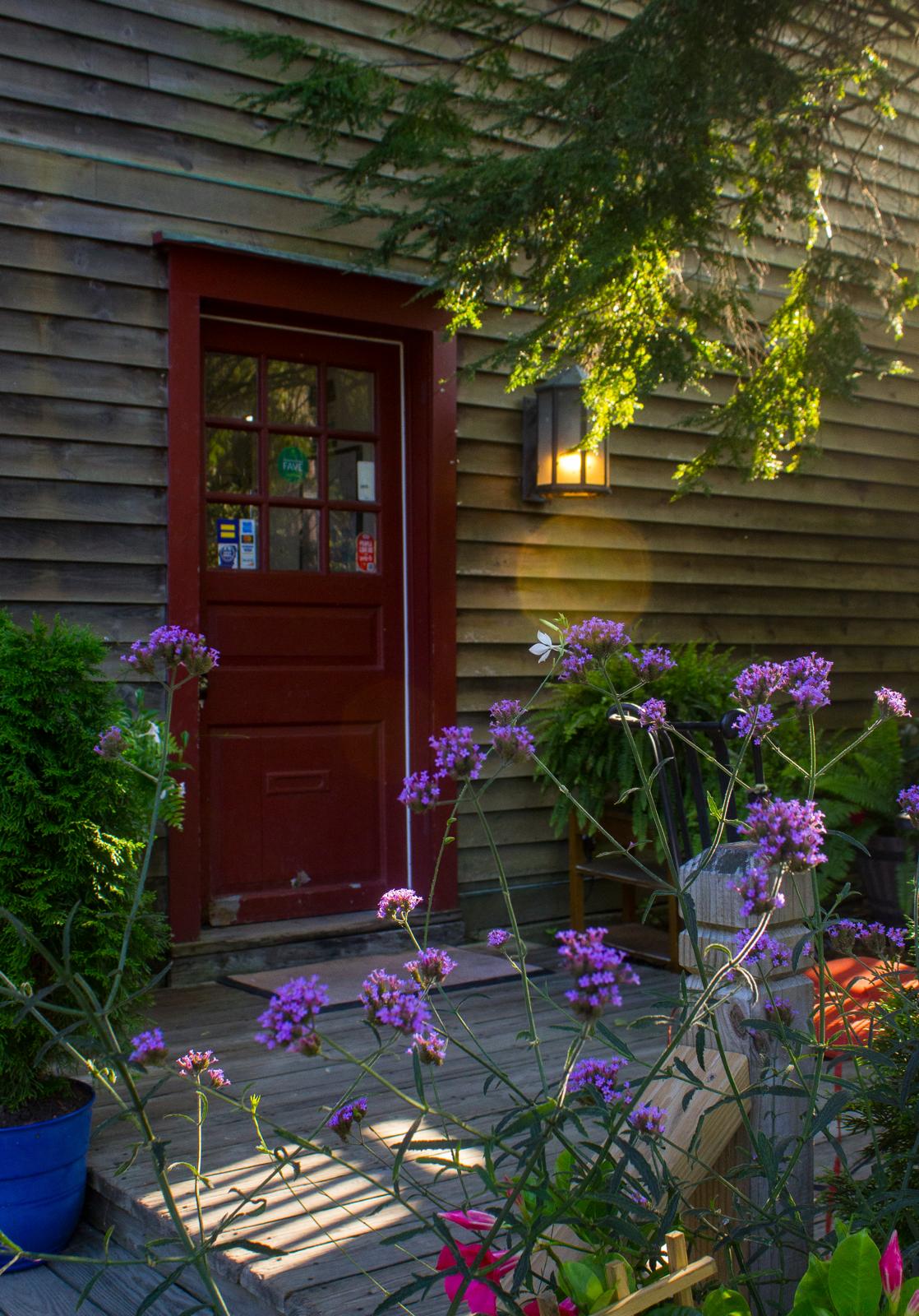 Red entrance surrounded by flowers and greenery at The Market at Union Hall