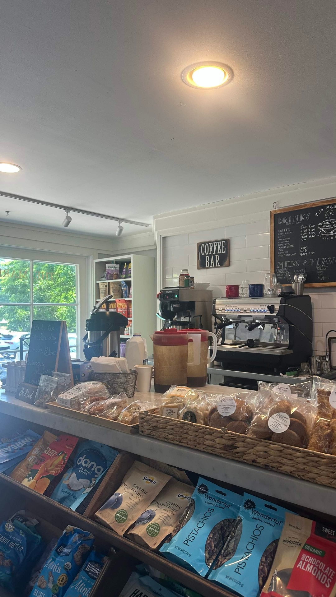Coffee bar with espresso machine, pastries, and baked goods